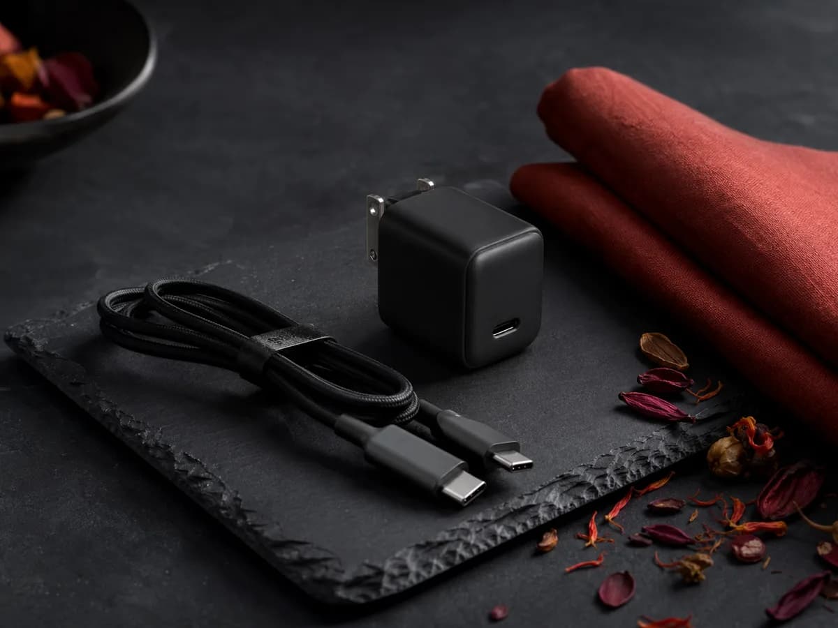 Nexode Air 65W served on a dark slate board with a folded paprika napkin and a scattering of dried petals