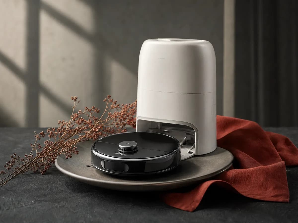 Qrevo Curv 2 Flow plated on a matte ceramic dish with a paprika-red linen napkin and a sprig of dried flowers